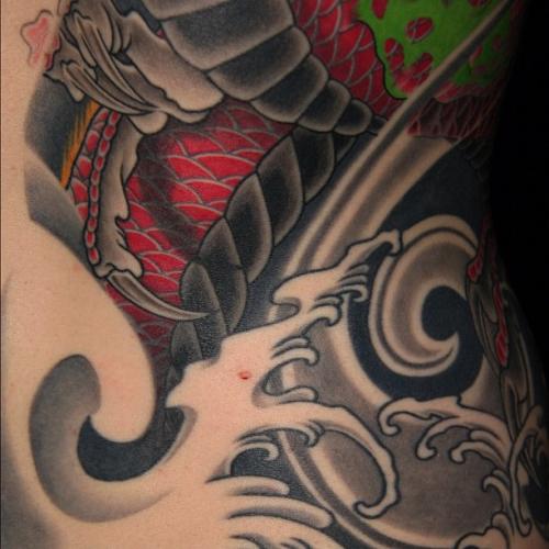 Detail of dragon and phoenix half back and sleeve tattoo